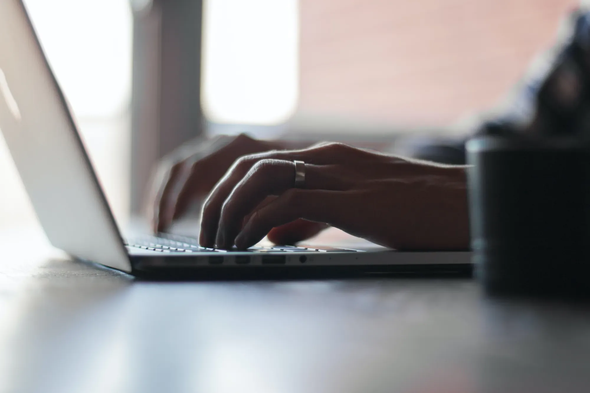 Hände tippen am Laptop – Online-Bewerbung