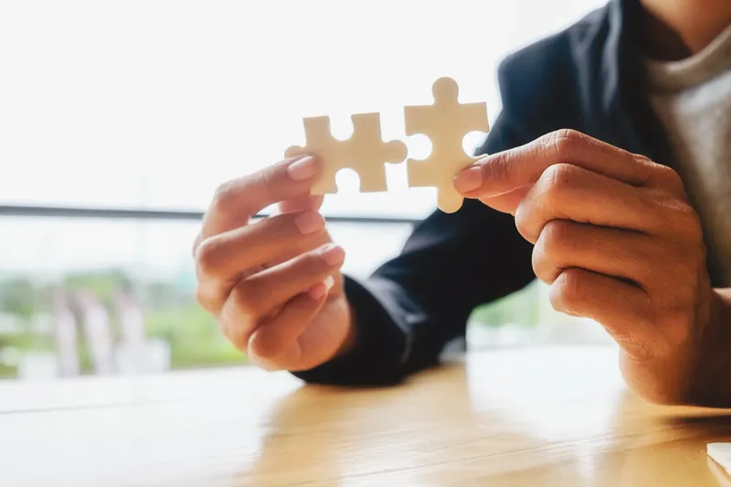 Zwei Puzzleteile werden zusammengefügt – Outsourcing als passende Lösung